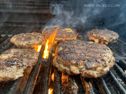 Cheese filled hamburgers being cooked on BBQ
